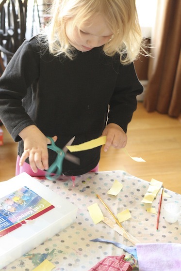 preschooler cutting strips of paper